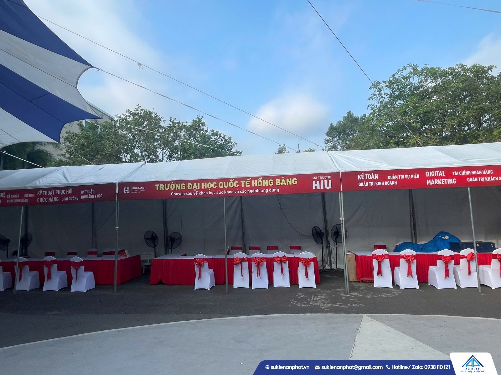 Dãy gian phục vụ với bàn phủ khăn và ghế tại sự kiện ngoài trời.